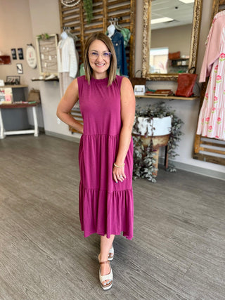 Woman wearing sleeveless tiered maxi dress with ruffled layers in boutique setting