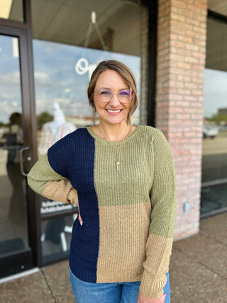 Woman wearing Blu Pepper colorblock knit sweater with ribbed texture, posing outside boutique storefront.