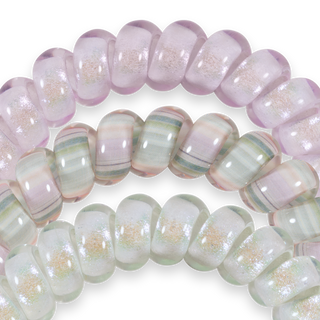 Three iridescent hair ties in soft pastel colors with shimmery, translucent finish displayed on black background.