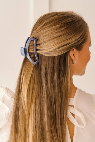 Woman wearing a geometric open hair clip in blonde highlighted hair with half-up hairstyle