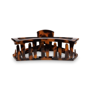Tortoiseshell hair clip with open comb design and curved shape for styling hair.