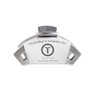 Silver metallic hair clip with curved design and TELETIES branding on white packaging.