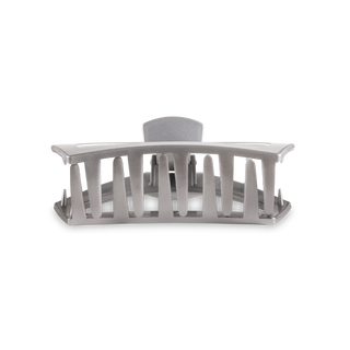 Clear plastic hair clip with open slotted design and curved shape for secure hair styling.