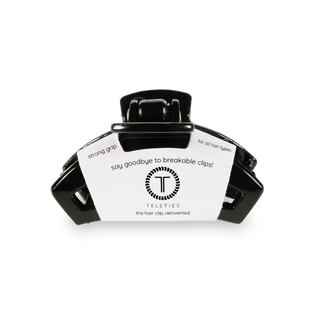 Black hair clip with white product tag featuring TELETIES branding and product information