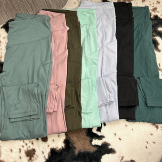 Collection of athletic leggings in various colors laid out on cowhide rug