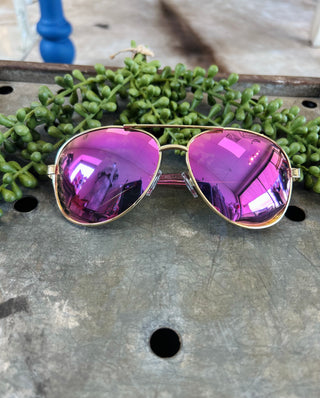 Stayson polarized aviator sunglasses with reflective purple lenses and gold frames on rustic wooden surface
