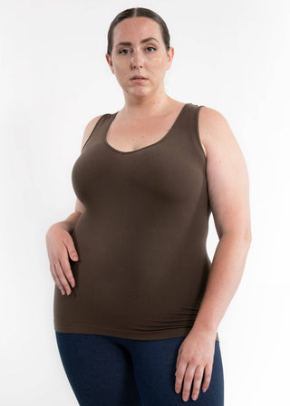 Woman wearing olive green sleeveless tank top with scoop neckline and dark jeans against white background.