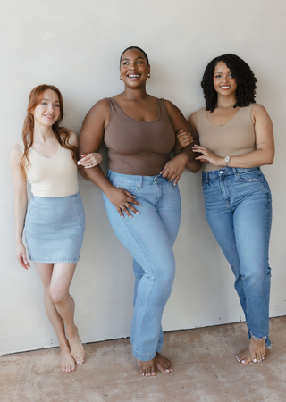 Three women wearing neutral-toned reversible camisoles with denim bottoms, showcasing different body types and styling opt...