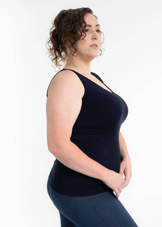 Woman wearing black reversible cami tank top with curly hair against white background