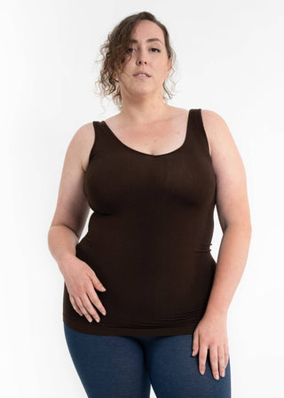 Woman wearing black sleeveless tank top with jeans in product photo against white background.