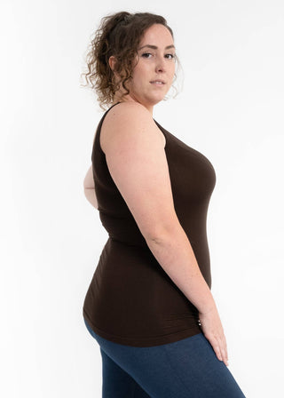 Woman wearing brown reversible cami tank top with blue leggings, shown from side angle.