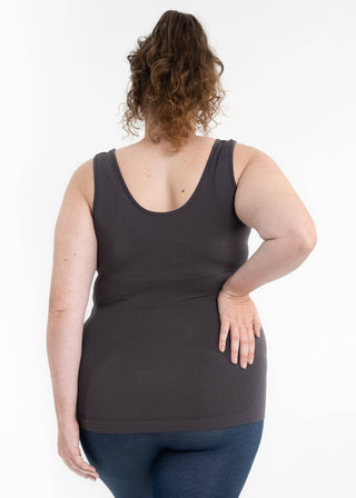 Woman wearing dark tank top and jeans, shown from behind with curly hair