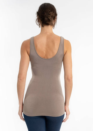 Woman wearing taupe tank top viewed from behind, showing scoop neckline and fitted silhouette.