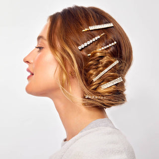 Woman wearing multiple sparkly rhinestone bobby pins in an elegant updo hairstyle, showcasing the decorative hair accessor...