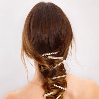 Woman with twisted hair adorned with sparkly rhinestone bobby pins from behind