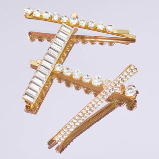 Gold-toned bobby pins embellished with clear rhinestones and crystals in various shapes and sizes.