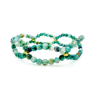 Three stacked beaded stretch bracelets with marbled stone beads and gold accent pieces.
