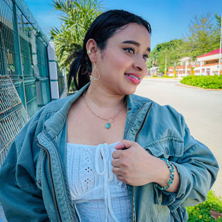 Young woman wearing the Alegria Accessories Rio Bracelet with matching turquoise jewelry set outdoors.