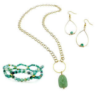 Gold teardrop hoop earrings with gemstone accent, shown alongside matching necklace and bracelets.