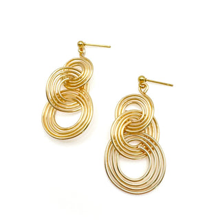 Gold ripple earrings with interlocking circular wire design and stud backs on white background