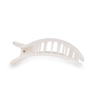 White round flat hair clip with curved design and textured grip pattern