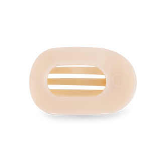 Round flat hair clip with striped pattern in neutral beige tones on black background