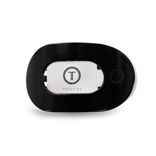 Black round flat hair clip with oval opening displaying TELETIES logo branding