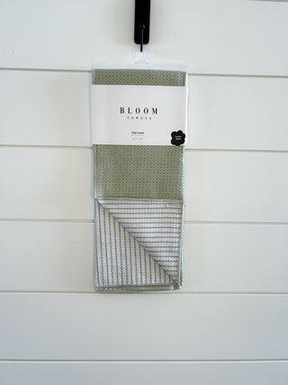 Bloom Towels dish towel with geometric pattern hanging on display hook against white tile background