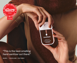 Person holding a Touchland Power Mist hand sanitizer with Allure Best of Beauty Hall of Fame badge.