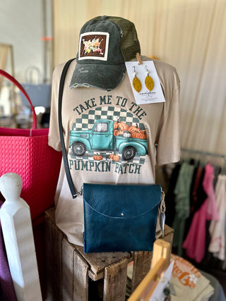 Sand vintage pumpkin patch graphic tee displayed on mannequin with fall-themed accessories in boutique setting.