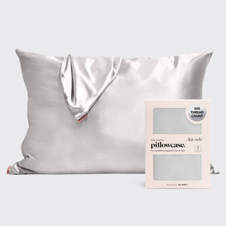 Silver satin pillowcase with product packaging showing 600 thread count and hair/skin benefits