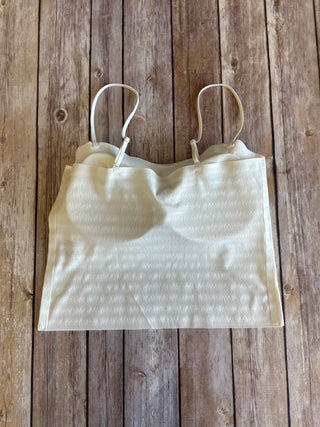 White striped bralette with adjustable straps laid flat on rustic wooden background