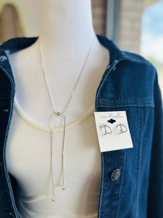 Mannequin wearing a dainty silver lariat necklace and Simply Noelle hoop earrings on denim jacket.