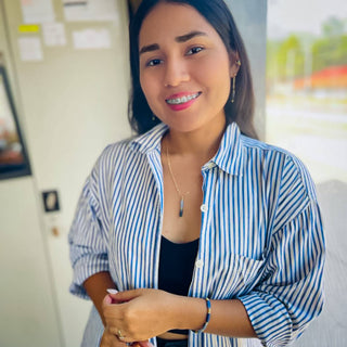 Woman wearing the Alegria Accessories Skye Necklace, a delicate pendant on a fine gold chain.