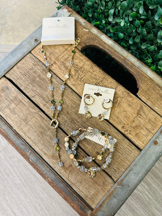 Simply Noelle slate blue and gold beaded necklace, bracelet, and earring jewelry set displayed on rustic wooden crate.