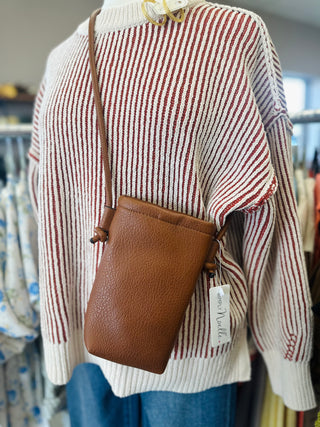 Ganz soft pebble mini crossbody bag displayed on mannequin wearing striped knit sweater.
