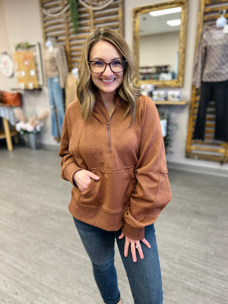 Woman wearing cozy ribbed quarter-zip hoodie with jeans in modern retail store setting