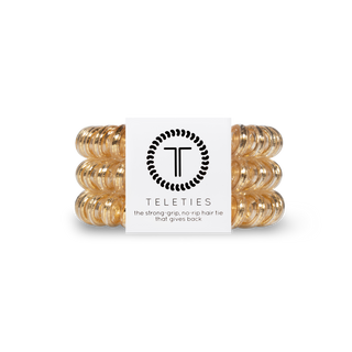 TELETIES spiral hair coils in gold color with brand packaging on black background