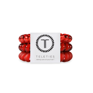 Red spiral hair coils displayed on either side of TELETIES branded packaging with logo