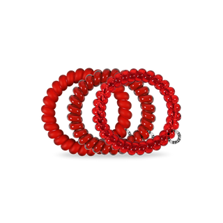 Red spiral hair coils arranged in a coiled display showing elastic hair ties