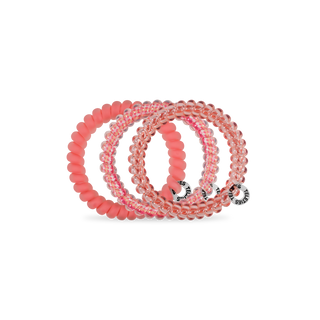 TELETIES spiral hair coils in coral pink and clear colors arranged in a display