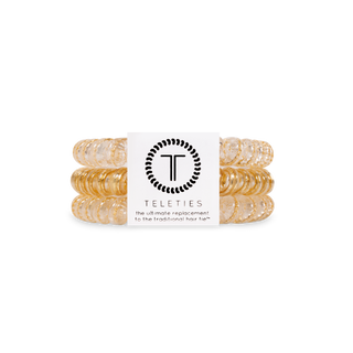 TELETIES spiral coil hair ties in a metallic gold finish, packaged in a set of three.