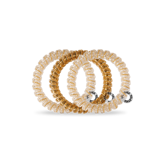 Three TELETIES spiral coil hair ties with clear and gold metallic finish, shown stacked together.