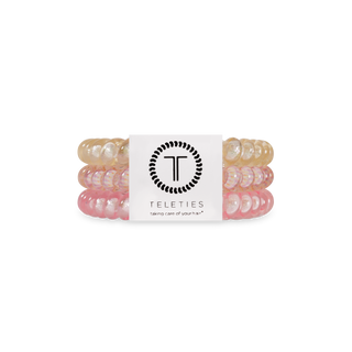 TELETIES spiral hair coils in translucent colors displayed in branded packaging with logo