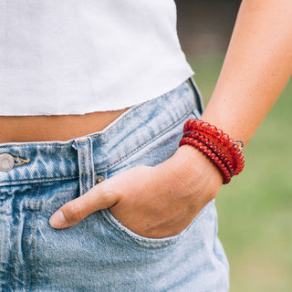 TELETIES spiral hair coils worn as bracelets on wrist with hand in denim pocket