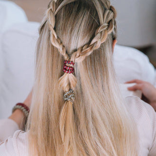 Woman with blonde hair wearing decorative spiral hair coils in a braided half-up hairstyle.