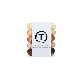 TELETIES spiral hair coils in nude tones displayed with white product packaging on black background