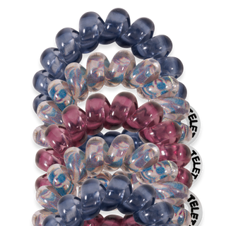 Colorful spiral hair coils in blue, pink and iridescent patterns arranged in stacks against black background