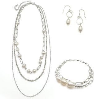 Silver-toned jewelry set with layered pearl necklaces, matching bracelet, and drop earrings on white background.