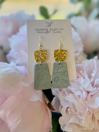 Handmade polymer clay earrings with gold glitter and sage green floral pattern on display card with pink peonies